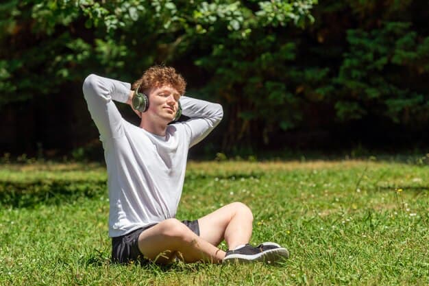 A guy sits on the grass and listens to music​​